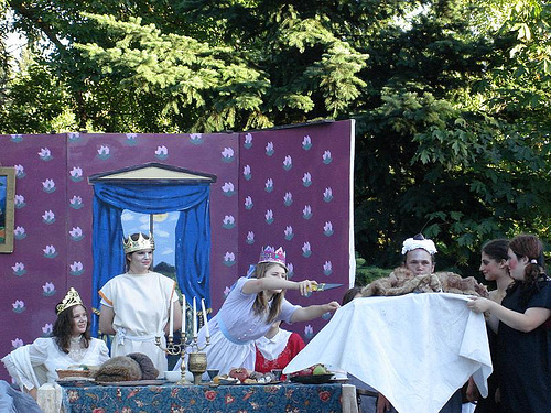 Children on a stage performing Alice Through the Looking Glass