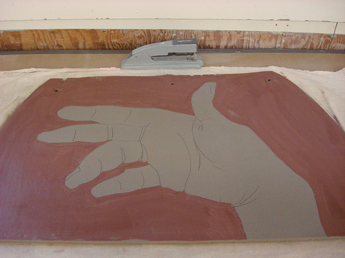 Large drawing of a hand done in clay