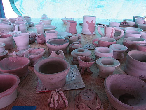 handmade pots under a blue tarp