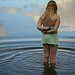 A girl standing in reflections and ripples