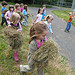Children carrying bundles of hay