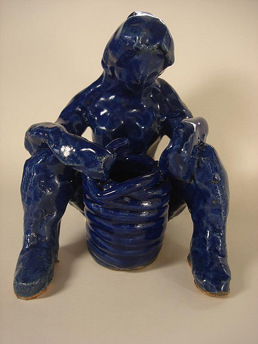 Cobalt blue woman holding a coil pot
